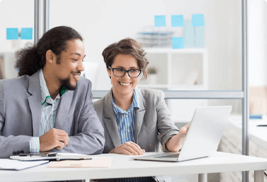 Mann und Frau schauen auf Laptop am Tisch, Frank Moser Coaching